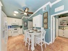 Step into your charming coastal-inspired kitchen and dining nook, where soft aqua walls and warm terracotta floors invite leisurely meals under the gentle hum of the ceiling fan.