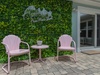 This Anna Maria Island property features a lush green wall entrance with charming pink seating, offering a welcoming arrival experience.