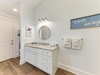 Freshen up in your bright, coastal-inspired bathroom with a granite vanity, oval mirror, charming artwork, and fluffy towels—all the comforts you need for a relaxing stay.
