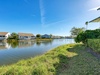 Peaceful waterfront community with canal homes and lush landscaping under brilliant blue skies.