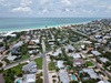 Aerial view of a coastal vacation neighborhood with pristine white-sand beaches and turquoise Gulf waters just steps away from the property.