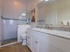 Freshen up in your elegant bathroom featuring a walk-in shower with mosaic tile accents and a spacious vanity with marble countertops—perfect for your morning routine.