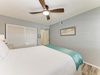 Drift off to peaceful sleep beneath the gentle whir of your wooden ceiling fan in this serene coastal bedroom retreat.