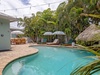 Escape to this private tropical oasis. Lounge under palm trees on sun-soaked chairs, cool off in the shimmering pool, and unwind under thatched shade in your own slice of paradise.