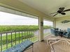 Your screened balcony offers comfortable seating with peaceful natural landscape views stretching into the distance.
