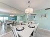 Your bright dining area features coastal charm with aqua walls, elegant chandelier, and table set for memorable meals together.
