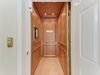 An elegant wood-paneled elevator with classic molding and warm lighting provides easy access throughout your stay. The 'RELAX' sign invites you to unwind as you move through this thoughtfully designed space.