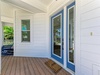 Step onto your private covered porch with tropical views and charming blue-trimmed doors welcoming you home.