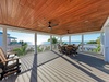 Breathe in ocean air on your spacious covered deck, where ceiling fans keep you cool while dining alfresco with stunning sea views stretching to the horizon.
