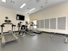 Stay active in your private fitness center featuring cardio equipment and strength training machines, all while enjoying entertainment on the mounted TV.