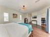 Unwind in your spacious bedroom with elegant chandelier lighting, warm wood floors, and thoughtful workspace—plus your own mounted TV for cozy evenings in.