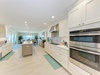 This bright, spacious kitchen flows seamlessly into the dining area, offering gleaming countertops, top-tier appliances, and plenty of room to cook and gather with loved ones.