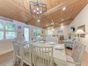 Gather around your bright dining table for memorable meals under the stunning wood ceiling and modern chandelier.