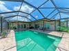A private screened pool with a covered patio invites you to relax in your own tropical oasis, perfect for sunny days and warm evenings.
