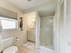 Your serene coastal-inspired bathroom features a spacious walk-in shower, soothing beachy decor, and soft natural light streaming through the window—a perfect retreat after a day of adventures.