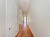 Stroll through your private hallway with gleaming hardwood floors and elegant pendant lighting guiding you to bright, welcoming spaces.