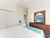 Your peaceful retreat awaits with a crisp white bed dressed in soft aqua accents, ample closet space, and coastal artwork that brings the beach vibe indoors for ultimate relaxation.