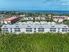 Aerial view of the modern beachfront property complex nestled between tropical vegetation and the stunning coastline.