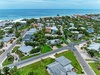 A beachfront vacation rental community nestled among palm trees, offering direct access to the pristine sandy beach and turquoise Gulf waters.