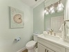 Your private coastal-themed bathroom awaits with soft seafoam tones, bright vanity lighting, and plush white towels—perfect for refreshing after a day at the beach.