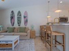 Unwind in this coastal-inspired living space where beachy vibes meet modern comfort. The open kitchen invites you to gather at the breakfast bar while the cozy sofa beckons for relaxation after sunny adventures.