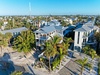 Aerial view of coastal vacation properties surrounded by tropical palms in a vibrant beachside community.