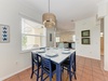 Gather around this inviting dining table, beautifully set and bathed in natural light. The coastal décor and open layout to the kitchen create a relaxed space for your memorable meals together.