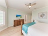 Step into your coastal retreat, where soft sage walls and beach-inspired décor create a serene escape. Relax under the ceiling fan's gentle breeze, surrounded by warm wood accents and crisp, inviting linens.
