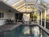 Your private screened pool awaits, perfect for leisurely swims or lounging poolside under the bright Florida sun. Enjoy alfresco dining and relaxation in this serene, tropical setting.