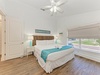 Drift off in this bright coastal bedroom, where a plush king bed, woven headboard, and turquoise accents invite you to unwind after a sun-soaked day at the shore.