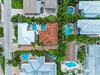Aerial view of a tropical vacation rental community featuring private pools, lush landscaping, and coastal architecture nestled among palm trees.