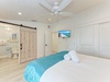 Relax in your coastal-inspired bedroom with crisp white linens, ceiling fan, and charming barn door bathroom.