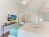 Your coastal retreat features a plush bed with beach-inspired linens, a mounted TV for movie nights, and vaulted ceilings that create an airy, relaxing atmosphere.