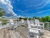 Step onto a sun-soaked deck where classic Adirondack chairs invite you to unwind with tropical views and endless Florida skies stretching overhead.