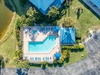 Aerial view showcases the resort's sparkling pool complex surrounded by lush tropical landscaping and convenient parking areas.