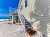 Beachfront property entrance with direct access to pristine white sand and turquoise waters.