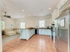 Your open-concept space blends a fully equipped kitchen with stainless steel appliances, granite countertops, and a charming island, plus a cozy living area with plush sectional seating—perfect for gathering, cooking, and unwinding together.