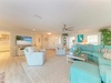 Unwind in your spacious living room featuring plush turquoise seating, coastal charm, and plenty of natural light—perfect for your family to gather and make vacation memories together.