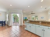 Enjoy your morning coffee in this bright, open kitchen with granite countertops and direct access to your private deck overlooking tropical palms.