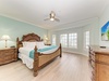 Step into this bright bedroom where tropical breezes meet coastal charm. You'll love the plush bed dressed in crisp linens, warm wood furnishings, and your own mounted TV for unwinding after sun-soaked days.