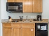 Kitchen Featuring Stove Top and Mini Fridge