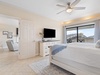 Primary bedroom with mounted flat-screen TV