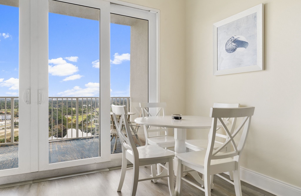 Dining area with natural light and balcony access overlooking the city.