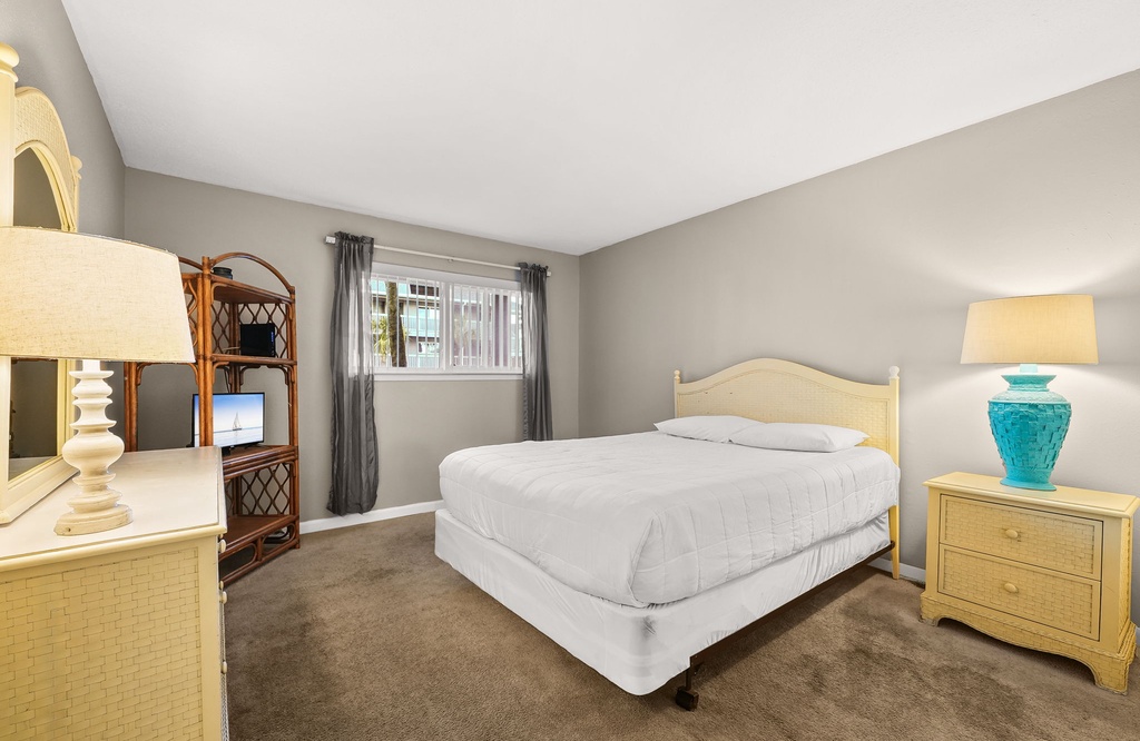 Simple bedroom with a queen bed and natural light from the window