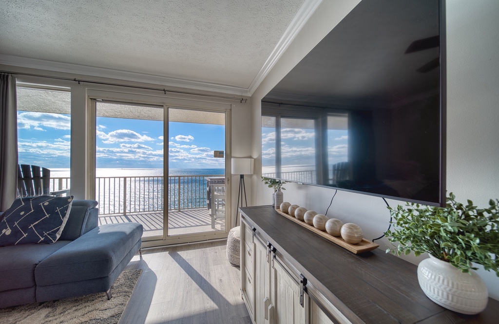 Unwind in your bright living room where floor-to-ceiling windows frame stunning ocean views. Relax on the plush sofa, step onto your private balcony, and let the coastal serenity surround you.