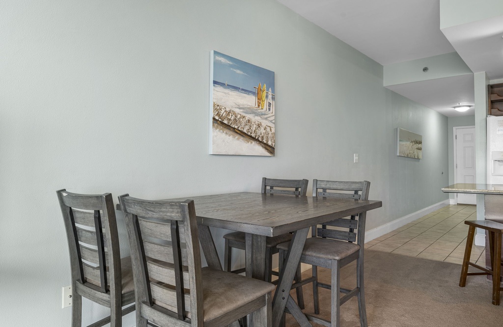 Dining area with rustic wooden table and chairs in a calm, light-filled space.