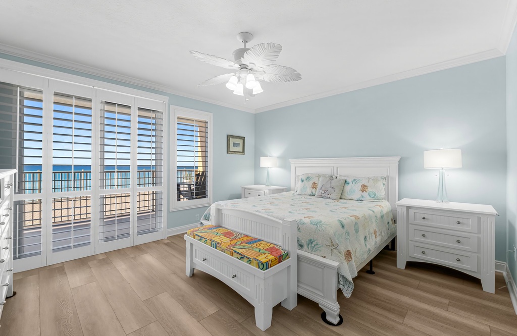 Relax in this coastal-inspired bedroom with ocean views through large glass doors.