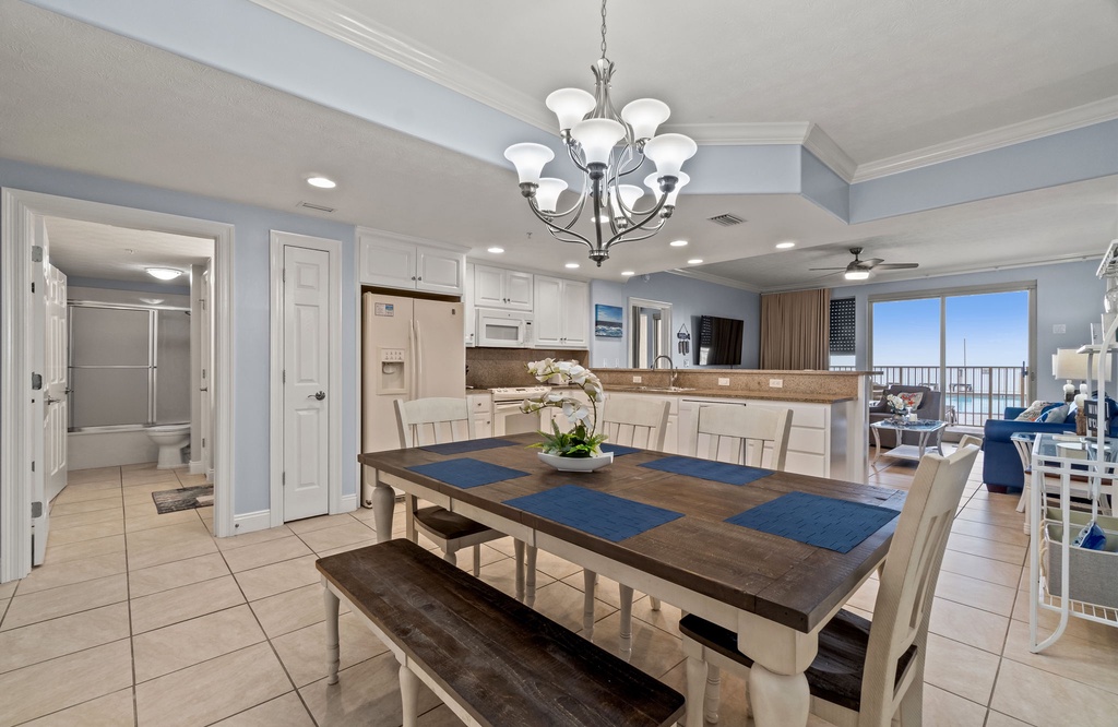 Open dining area with seating and a view into the living room and balcony.