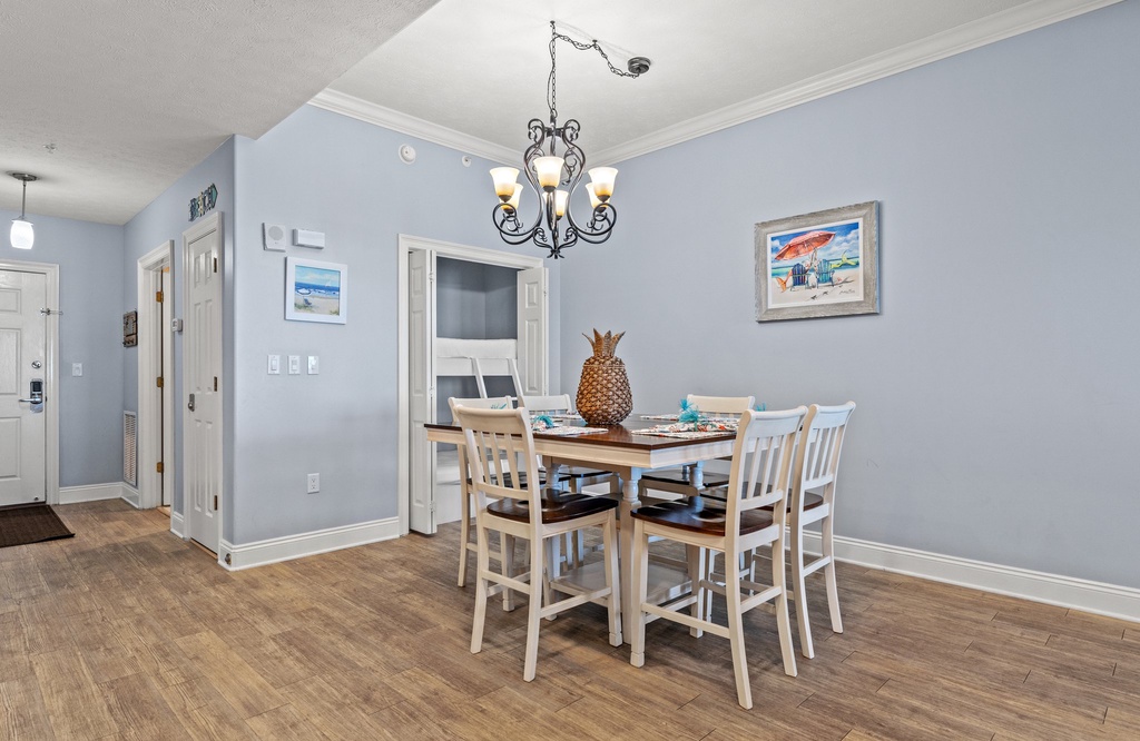 dining area with a wooden table and six chairs under a decorative chandelier