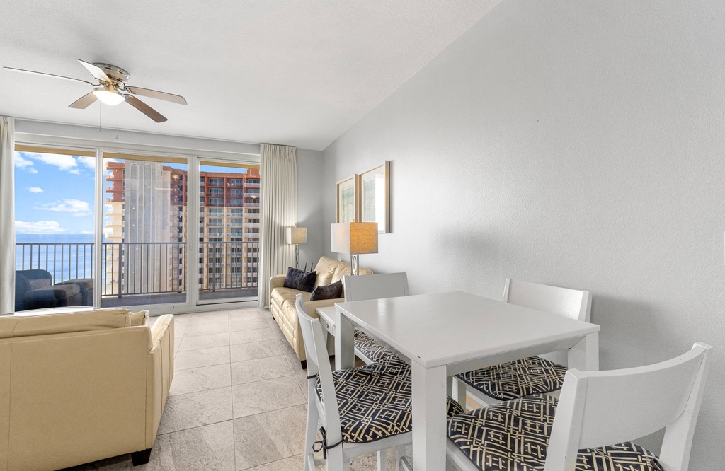 Modern living and dining area with balcony views of the city skyline.